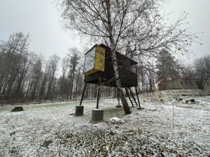 domek na drzewie siedzący na pokrytym śniegiem polu w obiekcie Posed v Moravském Berouně w mieście Moravský Beroun