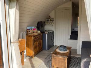 a kitchen with a stove and a table in a room at Secluded Cosy Luxury Pod in Shrewsbury