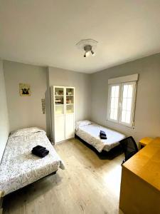 1 dormitorio con 2 camas y ventana en La Penca del Maguey en Santander