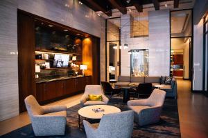 a lobby with chairs and a table and a bar at AC Hotel by Marriott Denver Downtown in Denver