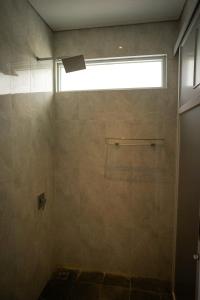 a bathroom with a shower with a window at Villa Languket I in Bedoyo