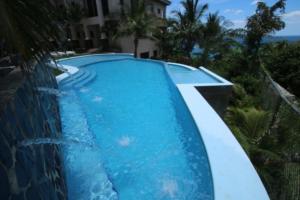 una piscina de agua azul en un complejo en Playa Flamingo - 2 BR condo with great ocean views - FLAMINGO TOWERS 25, en Playa Flamingo