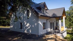 a white house with a black roof at Balasana - dom na wyłączność in Szklarska Poręba