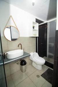 a bathroom with a toilet and a sink and a mirror at Moderno y acogedor departamento in Tacna