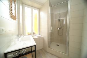 a white bathroom with a sink and a shower at Kyo Hôtel Restaurant in Thonon-les-Bains