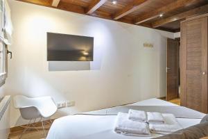 - une chambre avec un lit et une télévision murale dans l'établissement Luderna - Apartamento Val de Ruda B15 Baretja, à Baqueira-Beret