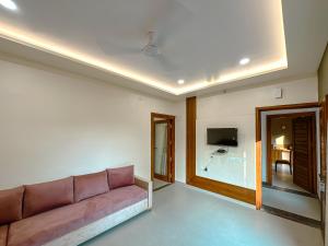 a living room with a couch and a television at Hotel Ananda Kashi in Varanasi