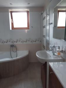 a bathroom with a tub and a sink at EROPLAN in Ružomberok