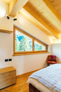 a bedroom with a bed and a window at Chalet M in Val di Zoldo