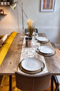 a wooden table with plates and glasses on it at Flat in the Heart of Worcester in Worcester