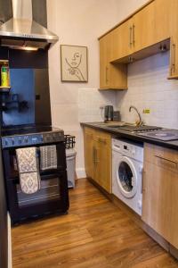 a kitchen with a stove and a washing machine at Flat in the Heart of Worcester in Worcester