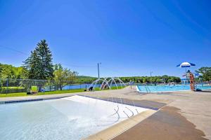 uma piscina com um parque aquático com um escorrega aquático em Arrowhead Lake Vacation Rental with Fire Pit! em Pocono Lake