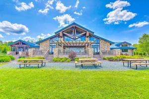 uma casa com mesas de piquenique em frente a um edifício em Arrowhead Lake Vacation Rental with Fire Pit! em Pocono Lake