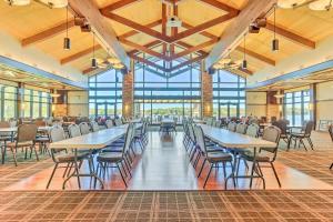 uma sala de jantar com mesas, cadeiras e janelas em Arrowhead Lake Vacation Rental with Fire Pit! em Pocono Lake