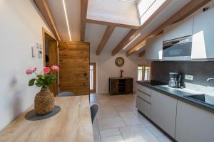a kitchen with a table and a vase with flowers on it at GARDA BALDO APARTMENTS in Nago-Torbole