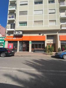 un edificio en una calle con coches aparcados delante en Studio Moderne au centre de ville casablanca à Louer, en Casablanca