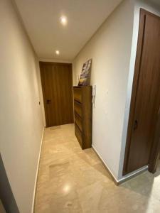 a hallway with a dresser and a wooden door at Studio Moderne au centre de ville casablanca à Louer in Casablanca