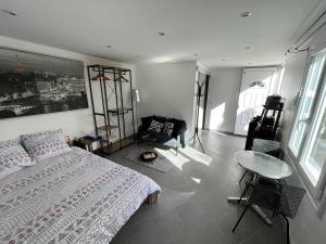 um quarto com uma cama, uma cadeira e uma mesa em Studio proche Paris et aéroport d'Orly em Orly
