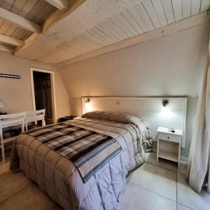 Un dormitorio con una cama y una mesa. en Hotel Tirol D'andrea en Villa General Belgrano