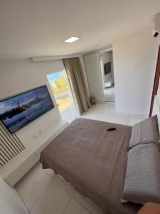 a bedroom with a large flat screen tv on a wall at Casa, Frente Mar, Vera Cruz, Ilha de Itaparica, Tairu! in Vera Cruz de Itaparica