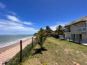 a fence next to a beach with a house at Casa, Frente Mar, Vera Cruz, Ilha de Itaparica, Tairu! in Vera Cruz de Itaparica