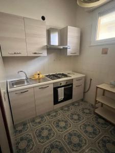 a kitchen with a stove and a sink at Da Ike residence con piscina in Santa Marinella