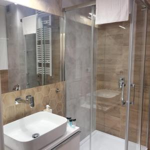 a bathroom with a white sink and a shower at Apartament Rodzinna Wyspa in Sianozety