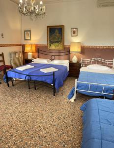 a bedroom with two beds and a chandelier at Princess Guest House Canal View in Venice