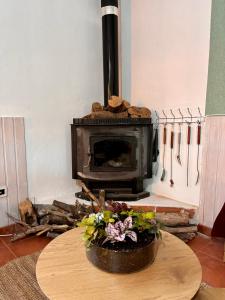 a fireplace in a room with a table with a flower arrangement at La Molinera Rustic in Cártama