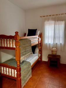 a bedroom with two bunk beds and a window at La Molinera Rustic in Cártama