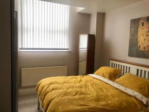 1 dormitorio con 1 cama con edredón amarillo en Flat in blue plaque building en Londres