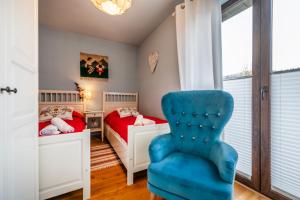 a bedroom with two beds and a blue chair at Sokołówka in Muszyna