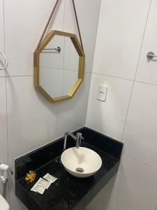 a bathroom with a sink and a mirror at Pousada portal mar in Maragogi