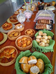 a table topped with baskets of different types of bread at Pousada Viver Capitólio in Capitólio