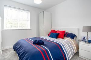 a bedroom with a bed with blue and red pillows at Modern Apartment Portrush in Portrush