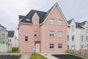 a pink house with a black roof at Modern Apartment Portrush in Portrush