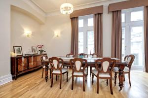 uma sala de jantar com mesa e cadeiras em Historic Whitehall flat in SW1 by UnderTheDoormat em Londres