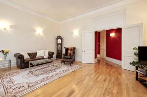 een woonkamer met een bank en een klok bij Historic Whitehall flat in SW1 by UnderTheDoormat in Londen