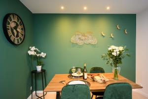 une salle à manger avec une table et des papillons sur le mur dans l'établissement COZY F2 40m2 Appartement Climatisé Château, à Montbéliard 16 autres photos