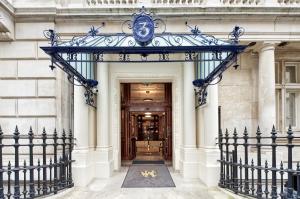 uma entrada para um edifício com um portão de ferro azul em Historic Whitehall flat in SW1 by UnderTheDoormat em Londres