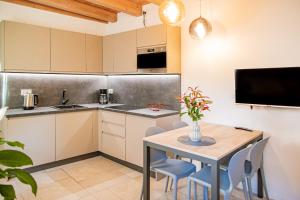a kitchen with a table and chairs and a television at GARDA BALDO APARTMENTS_VIVALDI in Nago-Torbole
