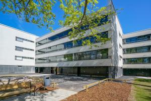 an office building with a bench in front of it at Forenom Serviced Apartments Espoo Tapiola in Espoo