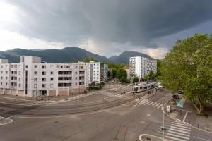 an empty street in a city with buildings and a bus at Le stade Clémenceau in Grenoble