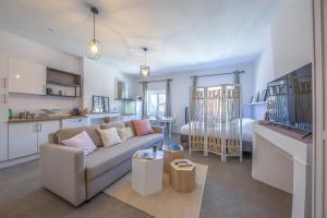 a living room with a couch and a kitchen at Le rendezvous cocooning des grenoblois in Grenoble