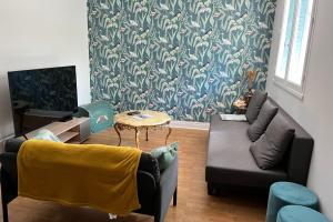 ein Wohnzimmer mit einem Sofa und einem Tisch in der Unterkunft Le Ferjus in Grenoble