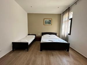 two beds in a room with wooden floors and a window at Dream holiday in Mestre