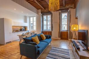 uma sala de estar com um sofá azul e uma cozinha em Sur les Traces du chevalier Bayard em Grenoble