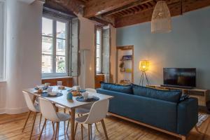 uma sala de estar com um sofá azul e uma mesa em Sur les Traces du chevalier Bayard em Grenoble