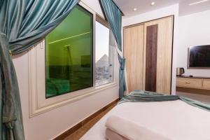 1 dormitorio con ventana grande y cama en Blue Pyramids Eyes Hotel, en El Cairo