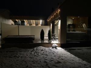 a house with snow on the ground at night at Guesthouse with sauna & hot tub & cold water pool in Nokia